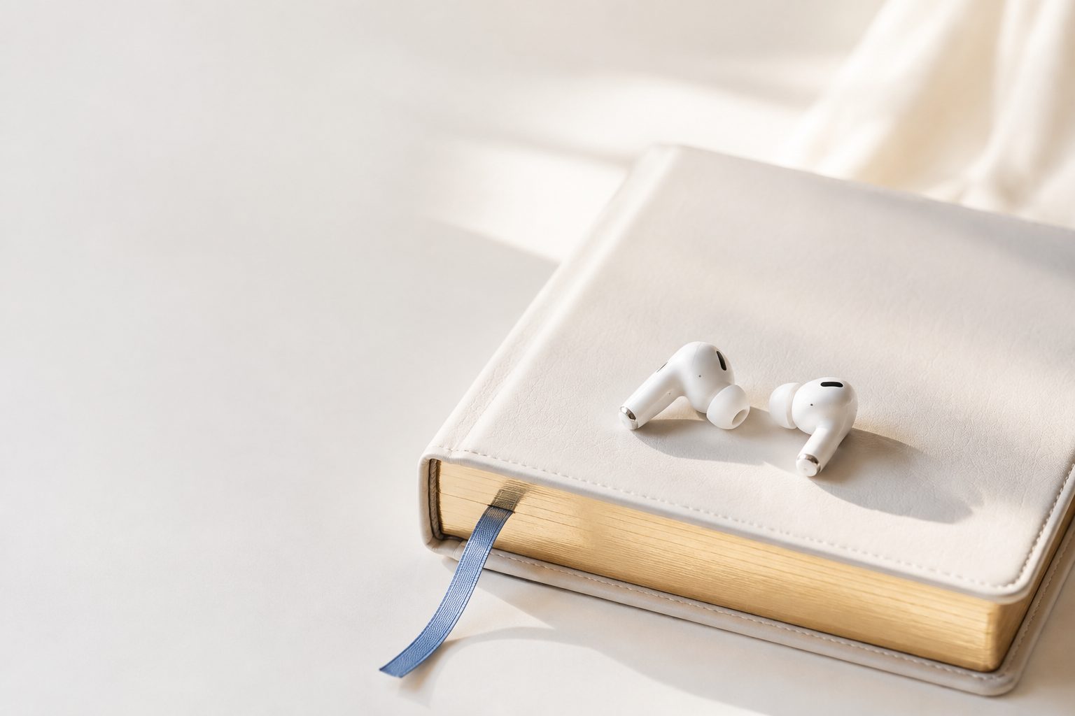 Fones de ouvido sem fio sobre uma B&iacute;blia com marcador azul
